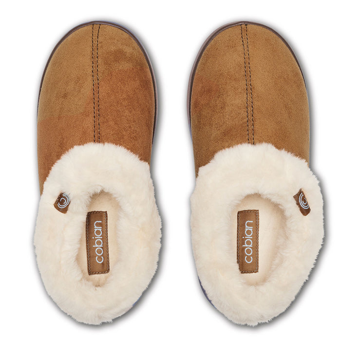 A pair of Cabián slip-on slippers shown from a top-down view. The slippers feature a tan suede upper and a thick, fluffy cream sherpa lining, with the Cobian brand name visible on the insole. #color_chestnut