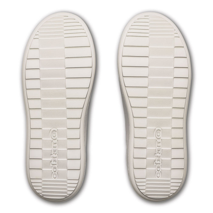 A pair of off-white rubber shoe soles shown from a top-down view, featuring a textured grid pattern and the embossed brand name 'colhano' near the heel. #color_black