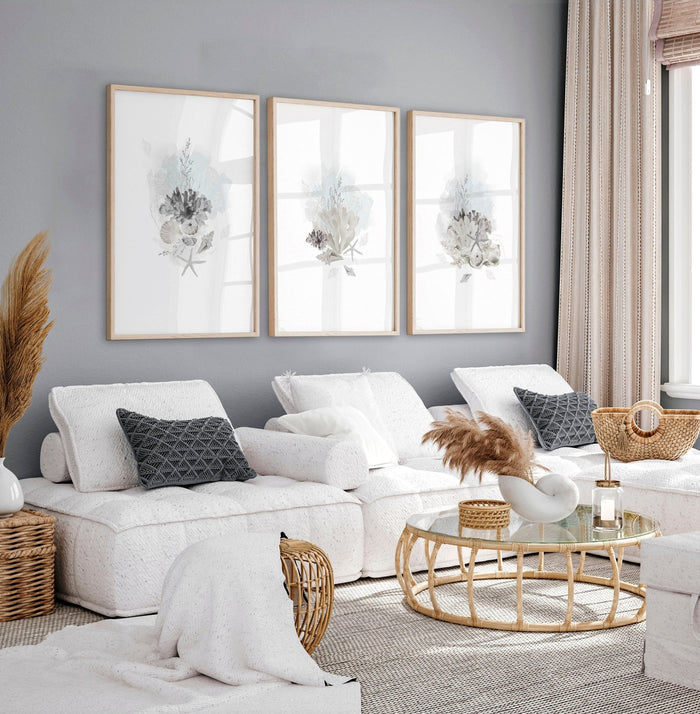 Three framed coastal watercolour prints above a white sofa, ideal decor for beach house interiors