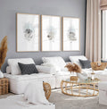Three framed coastal watercolour prints above a white sofa, ideal decor for beach house interiors