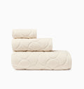 Oasi ivory bath towel, hand towel, and wascloth folded and stacked side view