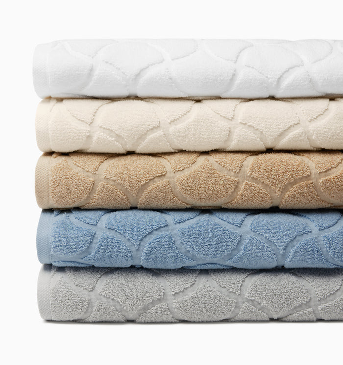 Oasi bath towels stacked from top to bottom in white, ivory, sand, sea and platinum.