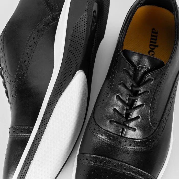 Detail photo of The Cap-Toe in Onyx Black and White Leather showing broguing and laces